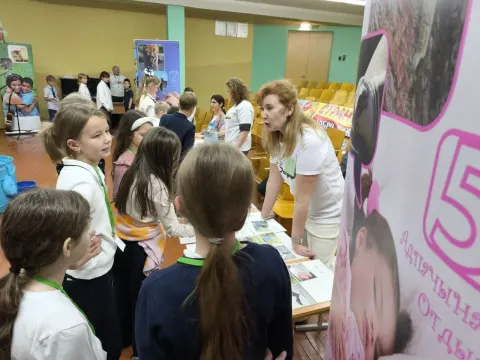 Школьники общаются с волонтёром у тематической станции