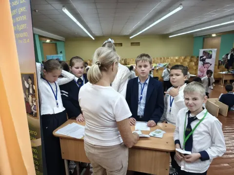 Волонтёр объясняет детям задание на станции здоровья